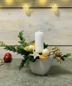 weiße Kerze im Gesteck zum Advent